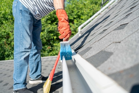 man cleaning gutter